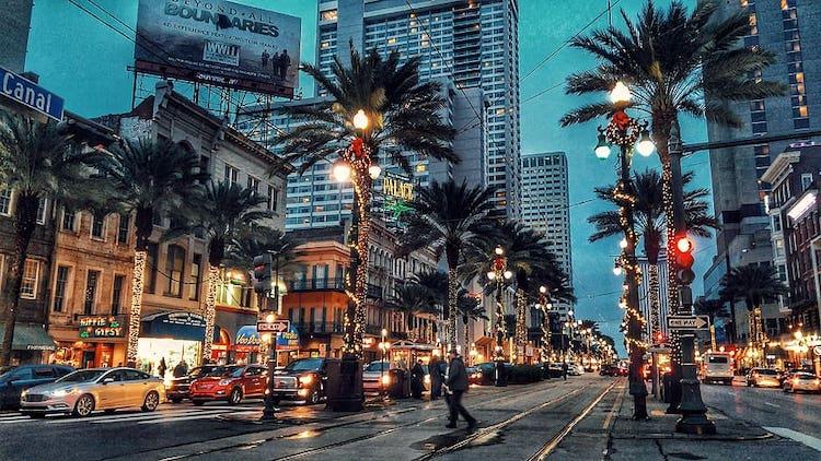 A photo of a bustling street in New Orleans in the evening.